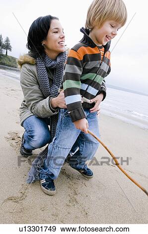 Stock Photo - Young woman and boy on beach, Vancouver, British Columbia. Fotosearch