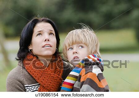 Young woman and boy with concerned expressions looking upward, Vancouver, British Columbia View Large Photo Image Picture - Young woman and boy with concerned expressions looking upward, Vancouver, British Columbia. Fotosearch