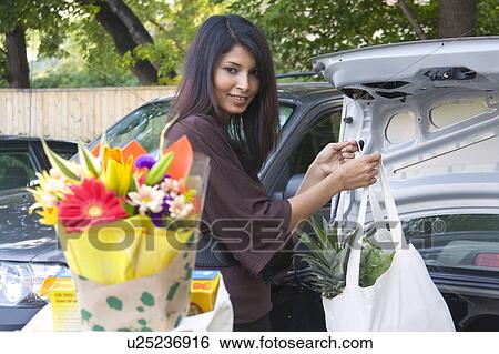 Young woman loading groceries in cloth bags, into car, Winnipeg, Canada View Large Photo Image Stock Photograph - Young woman loading groceries in cloth bags, into car, Winnipeg, Canada. Fotosearch