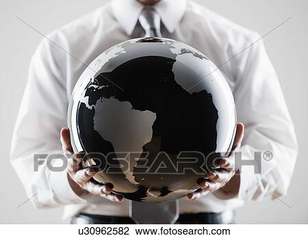 Stock Image - A businessman holding a globe. Fotosearch