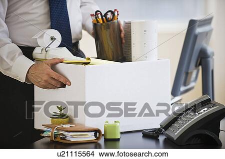 A businessman packing up desk View Large Photo Image Picture - A businessman packing up desk. Fotosearch