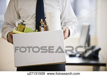 Stock Photo - A businessman with a box full of desk stuff. Fotosearch