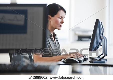 A businesswoman using a computer View Large Photo Image Stock Image - A businesswoman using a computer. Fotosearch