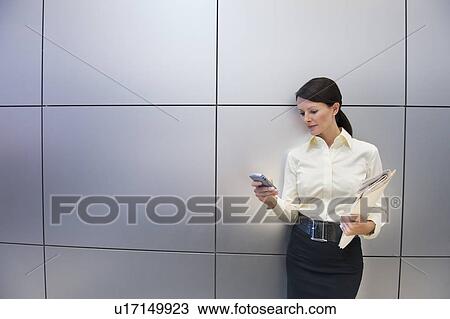 Stock Image - A businesswoman using a personal digital assistant. Fotosearch