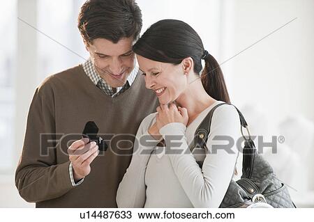 Stock Image - A couple looking at engagement rings. Fotosearch