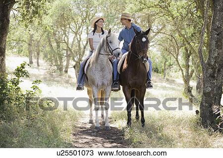Stock Image - A couple riding horses. Fotosearch