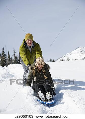 A couple sledding View Large Photo Image Stock Image - A couple sledding. Fotosearch