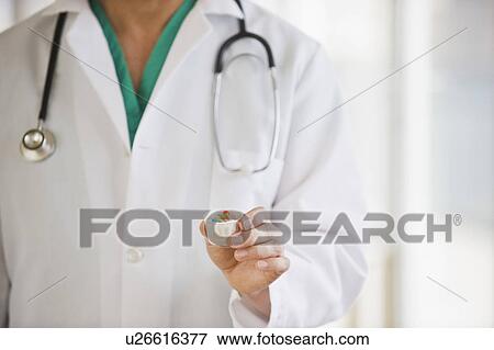 Stock Photo - A doctor holding some medication. Fotosearch
