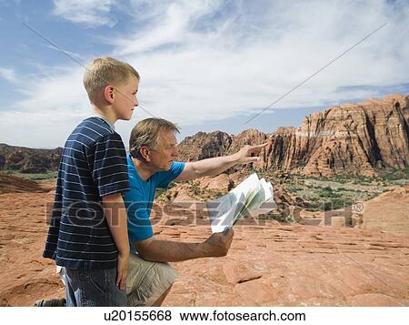Stock Photo - A father and son at Red Rock with a map. Fotosearch