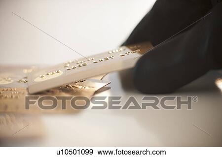 Stock Photo - A gloved hand stealing credit cards. Fotosearch