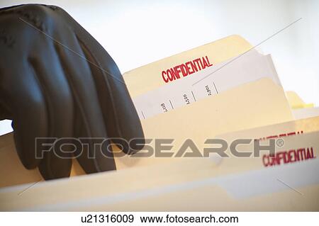 A gloved hand taking confidential files View Large Photo Image Stock Photo - A gloved hand taking confidential files. Fotosearch