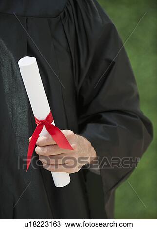 A graduate holding a diploma View Large Photo Image Stock Image - A graduate holding a diploma. Fotosearch