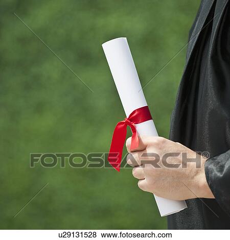 A graduate holding a diploma View Large Photo Image Stock Photo - A graduate holding a diploma. Fotosearch