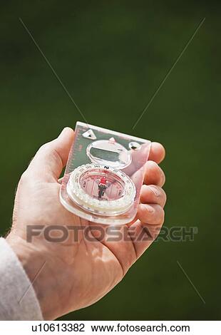 A hand holding a compass View Large Photo Image Stock Image - A hand holding a compass. Fotosearch
