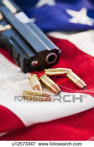 A handgun and ammunition on the American flag View Large Photo Image Stock Photo - A handgun and ammunition on the American flag. Fotosearch