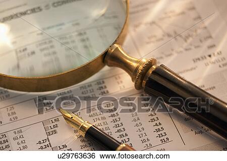 Stock Photograph - A magnifying glass and pen on paperwork. Fotosearch