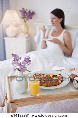 Stock Image - A man bringing a woman breakfast in bed. Fotosearch