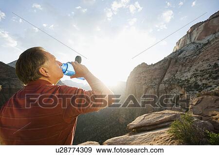 Stock Photo - A man drinking water at Red Rock. Fotosearch