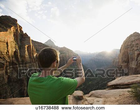 Stock Photo - A man taking a picture at Red Rock. Fotosearch