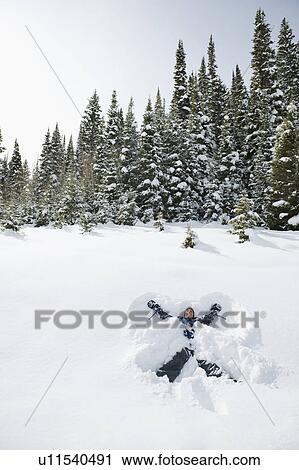 Stock Image - A person making snow angels. Fotosearch