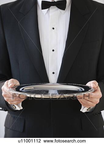 Stock Image - A server holding a silver tray. Fotosearch