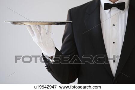 Stock Photo - A server holding a silver tray. Fotosearch