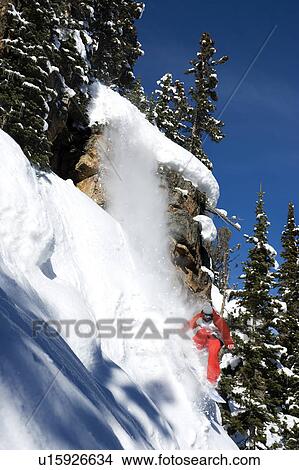 A snowboarder coming off a cliff View Large Photo Image Picture - A snowboarder coming off a cliff. Fotosearch