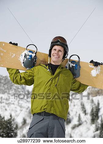 A snowboarder holdiing his snowboard View Large Photo Image Stock Photo - A snowboarder holdiing his snowboard. Fotosearch