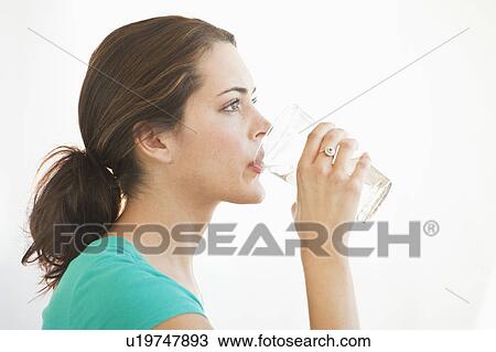 Stock Image - A woman drinking a glass of water. Fotosearch