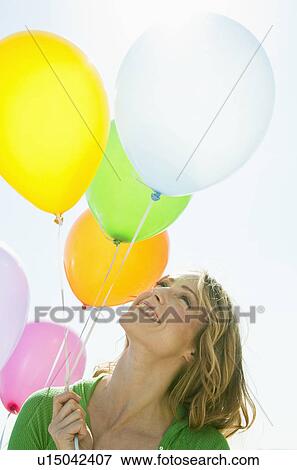 A woman holding balloons View Large Photo Image Stock Photo - A woman holding balloons. Fotosearch