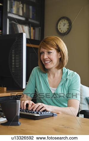 A woman in a home office View Large Photo Image Stock Image - A woman in a home office. Fotosearch
