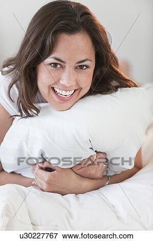 A woman relaxing in bed View Large Photo Image Stock Photo - A woman relaxing in bed. Fotosearch
