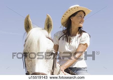 Stock Image - A woman riding a horse. Fotosearch