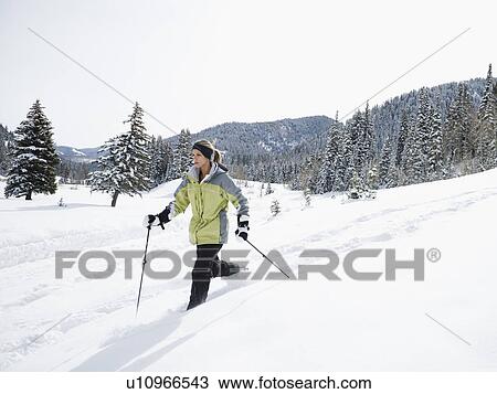 Stock Image - A woman snow shoeing. Fotosearch