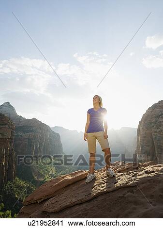 Stock Image - A woman standing at an apex at Red Rock. Fotosearch
