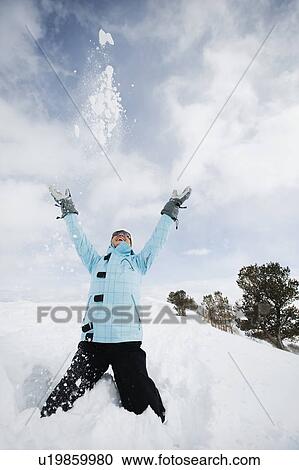 A woman throwing snow up in air View Large Photo Image Stock Image - A woman throwing snow up in air. Fotosearch