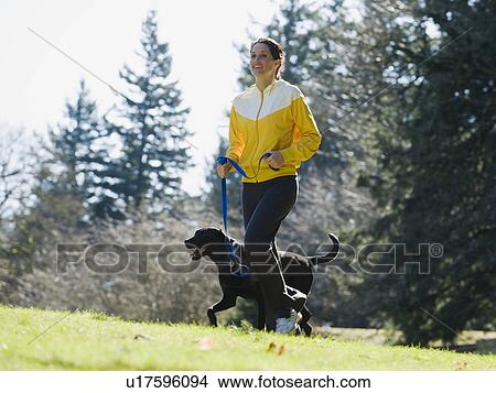 Picture - A woman with a dog outdoors. Fotosearch