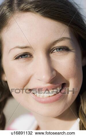 A young woman outdoors smiling View Large Photo Image Stock Image - A young woman outdoors smiling. Fotosearch