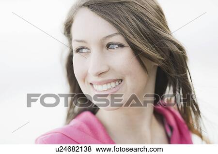 Stock Photo - A young woman outdoors smiling. Fotosearch