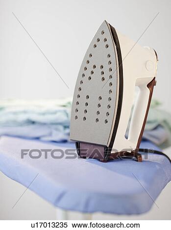 An iron on a ironing board View Large Photo Image Stock Photography - An iron on a ironing board. Fotosearch