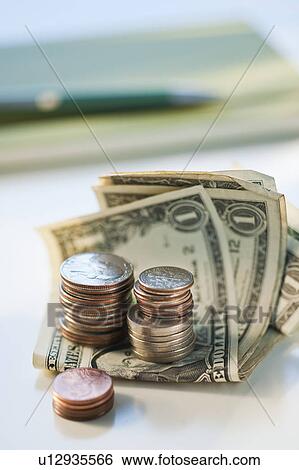 Bank notes and coins by a pad and pen View Large Photo Image Stock Photograph - Bank notes and coins by a pad and pen. Fotosearch