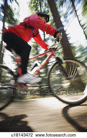 Stock Image - Biker in the woods. Fotosearch