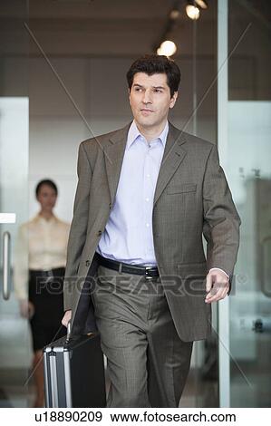 Businessman in office with briefcase View Large Photo Image Stock Photo - Businessman in office with briefcase. Fotosearch