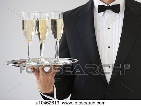Champagne being served on a silver tray View Large Photo Image Stock Photo - Champagne being served on a silver tray. Fotosearch