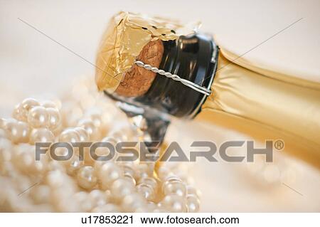 Stock Image - Champagne bottle and pearl necklace. Fotosearch