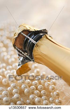 Stock Photo - Champagne bottle and pearl necklace. Fotosearch