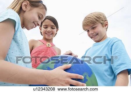Children holding a globe View Large Photo Image Stock Photo - Children holding a globe. Fotosearch