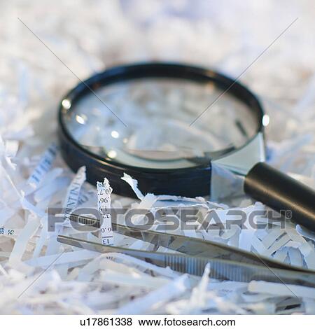 Confidential paperwork shredded with a magnifying glass and tweezers View Large Photo Image Stock Photo - Confidential paperwork shredded with a magnifying glass and tweezers. Fotosearch