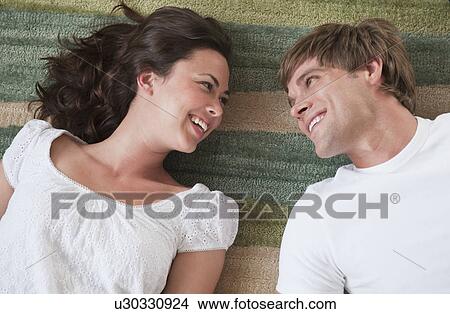Couple lying in living room View Large Photo Image Picture - Couple lying in living room. Fotosearch