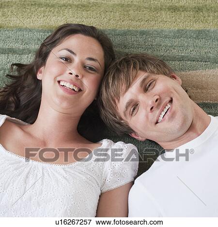 Couple lying in living room View Large Photo Image Stock Photo - Couple lying in living room. Fotosearch